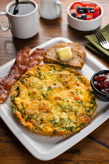 Omelette. Classic American brunch or breakfast menu item served at traditional American restaurant. Farm fresh eggs, cooked in butter with fresh vegetables pork, bacon, cheese and served with salad 