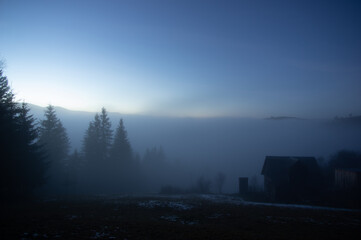 Evening, fog and a house in a mountain Carpathian village