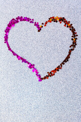 Heart shape made of multicolored glitter. Heart on ultimate gray glitter background. Valentine's Day concept. Copy space. Top view