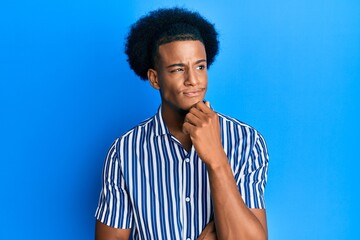 African american man with afro hair wearing casual clothes thinking concentrated about doubt with finger on chin and looking up wondering