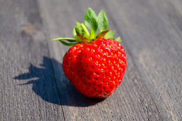 Strawberries on a wooden table in the summer outdoors