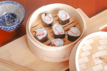 Salmon sushi typical of Japanese cuisine on black plate, natural light inside restaurant