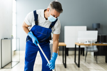 Male Janitor Mopping Floor In Face Mask