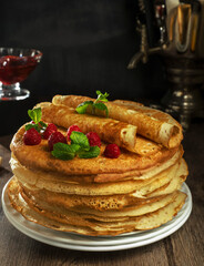 pancakes with raspberry jam and samovar on a wooden table, Russian breakfast