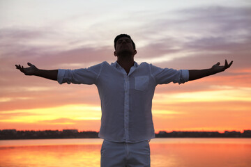 Fototapeta premium Man near river at sunset. Nature healing power
