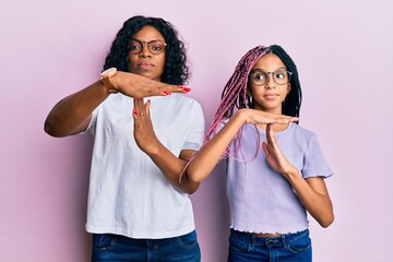 Beautiful african american mother and daughter wearing casual clothes and glasses doing time out...