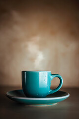 blue cup of coffee or tea. still life dark mood. cozy home evening. Wall with shadows and copy space for your products. vertical photo.