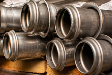 Metal pipes for the automotive industry are stored in a warehouse on a rack.