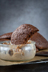 Close up of a fluffy chocolate brownie cookie placed inside a bowl of peanut butter ice cream. Healthy homemade gluten free chocolate chip cookies on a cooling rack.	