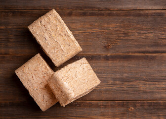 Set of fuel briquettes on a wooden background. Pressed sawdust fuel briquettes. Briquettes for the oven close-up. 