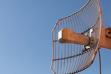 Mesh antenna for cellular telecommunications network and wireless internet against a blue sky....