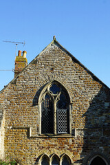 Rye, England - The brick exterior and a decorative window of an old church in Rye.  Image has copy...