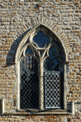 Obraz premium Rye, England - The brick exterior and a decorative window of an old church in Rye. Image has copy space.