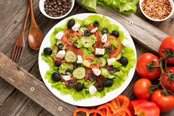 Freshly prepared Greek salad with feta cheese and various seasonings.