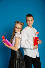 A couple of schoolchildren are teenagers on Valentine's Day on a blue background