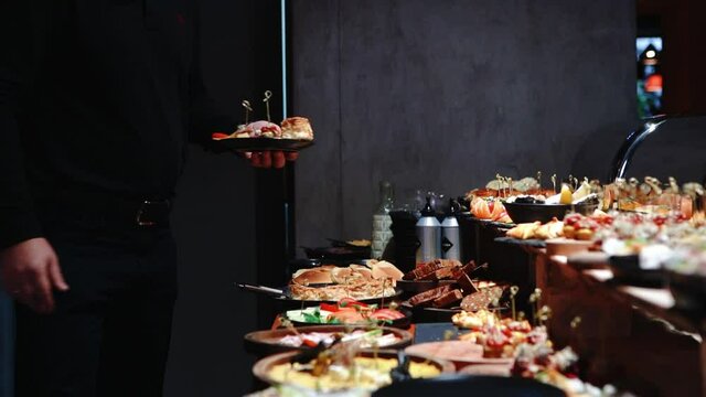 Buffet heated trays with sausages, in hotel luxury restaurant. All inclusive. Buffet food. Hotel serves buffet for breakfast. People with plates choose their dishes. Dining at the hotel of Egypt