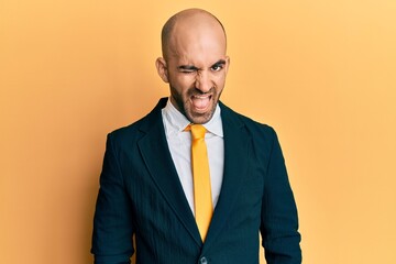 Young hispanic man wearing business suit and tie winking looking at the camera with sexy expression, cheerful and happy face.