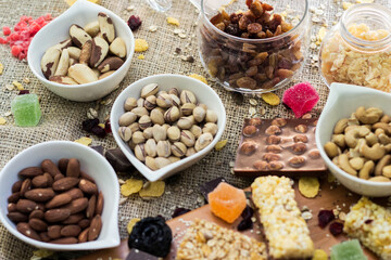 Granola Bars and mixed nuts. Honey bars with peanuts, chocolate, dried fruit, sesame and sunflower seeds