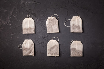Tea bags on black stone background