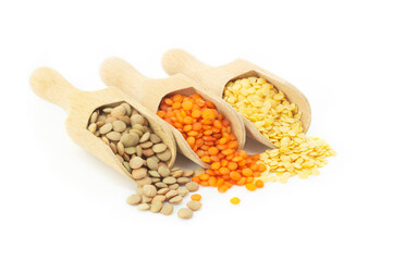 Uncooked raw red, yellow and green lentil in wooden shovel isolated on white background, (Lens culinaris)