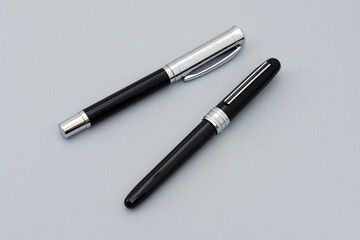 Fototapeta premium Metallic signature pens on the gray background.