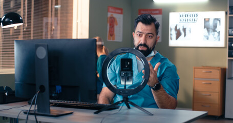 Bearded male doctor making video call to colleagues