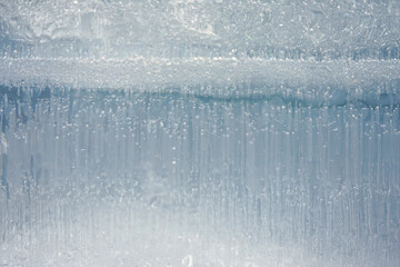 Fototapeta na wymiar Close-up view of a structure of a large block of light blue ice with air bubbles and cavities