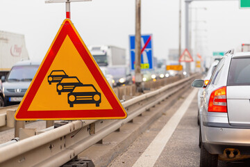 Traffic jam sign on a highway with line of cars waiting in row. Concept of delayed traffic during...
