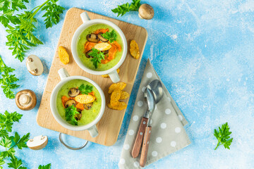 Creamy cauliflower soup with toasted bread croutons on blue tabletop. Vegetarian healthy food concept. Ideas and recipes for winter meal. Top view, flat lay.
