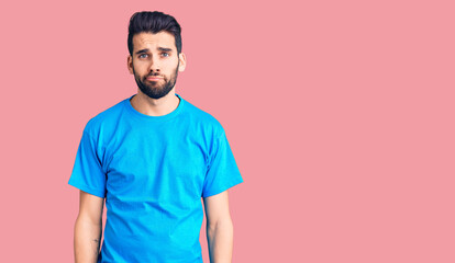Young handsome man with beard wearing casual t-shirt depressed and worry for distress, crying angry and afraid. sad expression.