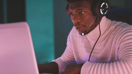 Black man with illuminated headphones, gamer or game commentator . High quality photo