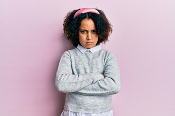 Young little girl with afro hair wearing casual clothes skeptic and nervous, disapproving expression on face with crossed arms. negative person.