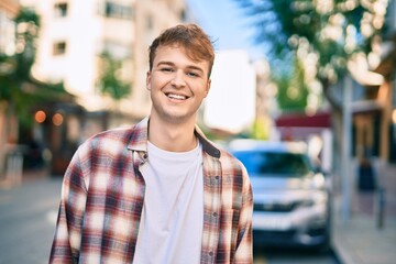 Fototapeta premium Young caucasian man smiling happy standing at the city.