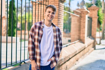 Young caucasian man smiling happy standing at the city.