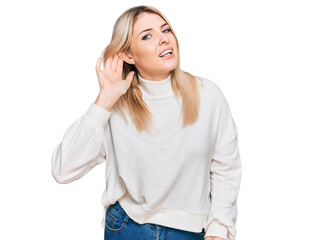 Young caucasian woman wearing casual winter sweater trying to hear both hands on ear gesture, curious for gossip. hearing problem, deaf