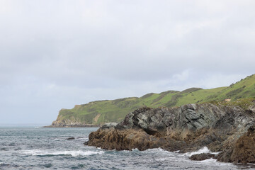 Fototapeta na wymiar Clouds over the rocks and water off the cornish coast