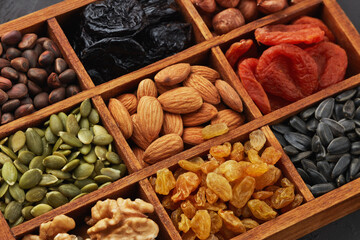 Different kinds of nuts, dried fruits in wooden box. Healthy food. Top view. Vegetarian nutrition