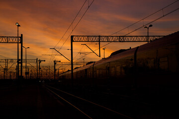 Plakat Colorful sky at sunset with visible elements of the railway infrastructure.
