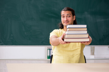 Young male student preparing for exams in the classroom