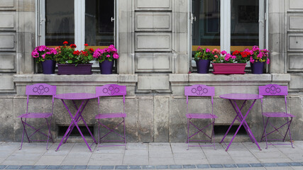 Fototapeta na wymiar Small terrace on the street with purple chairs and tables in the villages of Troyes in France