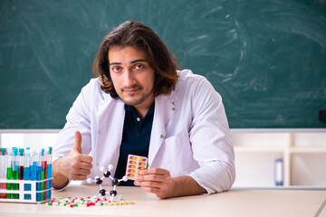 Young male scientist sitting in the classroom