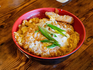 Close up shot of a deep fried pork cutlet with fried egg