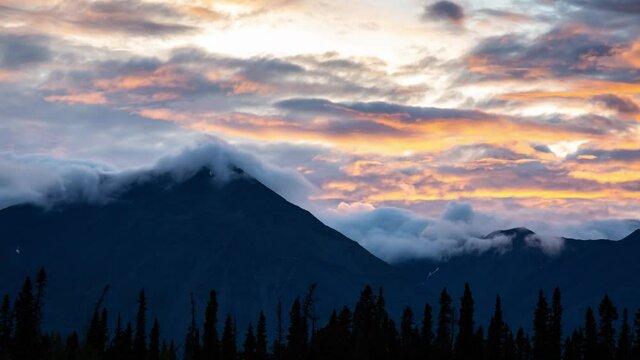 Time Lapse. Beautiful View of Canadian Nature with Mountains in the Background. Cloudy Sunset. Kathleen Lake, Kluane National Park, Yukon, Canada. Pan Up
