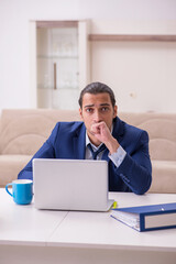 Young male employee working from home in pandemic concept