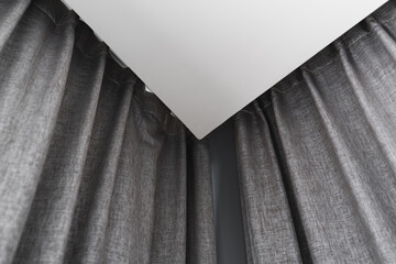 Gray curtain with rails, installed on ceiling