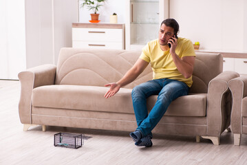 Obraz premium Young man and mousetrap at home