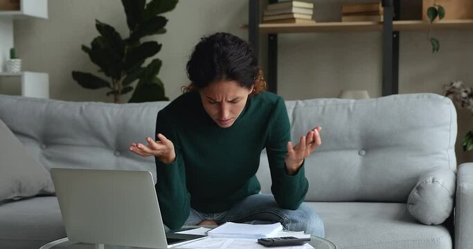 Woman sit on sofa do accountancy work from home, calculates personal finances feels upset about financial problems. Miscalculation, search mistake, bankruptcy, bookkeeping job, lack of money concept
