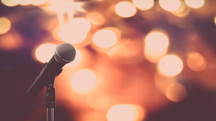 Obraz premium Public speaking backgrounds, Close-up the microphone on stand for speaker speech presentation stage performance with technology blur bokeh light background.