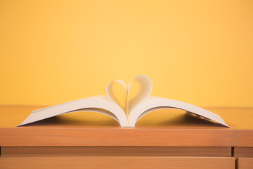 Close up pang of a book in heart shape on the table at library room of lifestyle love to read and reading a text book and February valentine day concepts. - obrazy, fototapety, plakaty