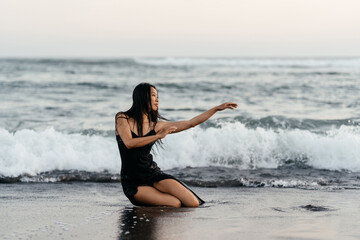 Fototapeta na wymiar Smile Freedom and happiness chinese woman on beach. She is enjoying serene ocean nature during travel holidays vacation outdoors. asian beauty. summer time